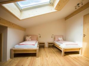 Stadelwohung Comfortable holiday residence في Argenbühl: سريرين في غرفة بها منور