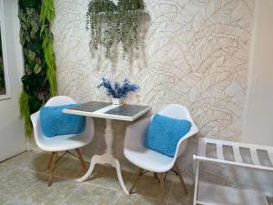 a table and two chairs with blue pillows at Jazmin's Apartment in Oranjestad