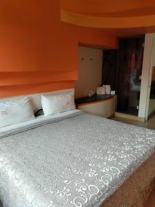 een slaapkamer met een groot bed met een oranje muur bij Motel Éxtasis in Mexico-Stad