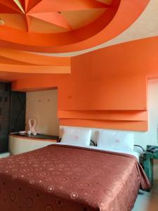 een bed in een kamer met een oranje plafond bij Motel Éxtasis in Mexico-Stad