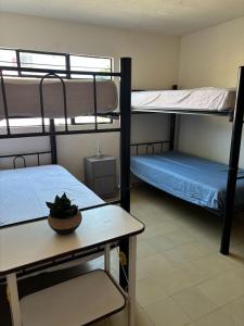 a room with two bunk beds and a table at Hostal Casa Herrera in Guadalajara