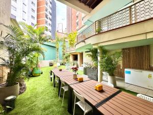 a patio with a long wooden table and chairs at DUO BOUTIQUE HOTEL in Medellín