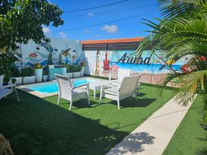 a patio with a table and chairs next to a pool at Jazmin's Apartment in Oranjestad