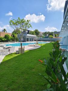 a large yard with a swimming pool and green grass at Babylon Sky Garden 2 in Rawai Beach +25 photos