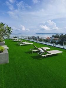 a row of benches sitting on top of green grass at Babylon Sky Garden 2 in Rawai Beach