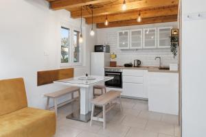 a kitchen with white cabinets and a table and chairs at Relax Bovec in Bovec