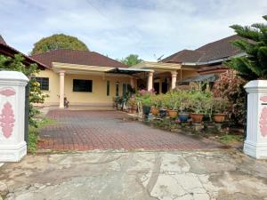 una casa con una entrada de ladrillo delante de ella en The Scholar's Den Homestay, en Kampong Bukit Kechil