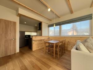 a kitchen and living room with a table and a couch at Hakuba Icicle House in Hakuba