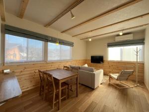 a living room with a table and a couch at Hakuba Icicle House in Hakuba