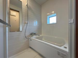 a bathroom with a tub and a sink and a mirror at Hakuba Icicle House in Hakuba +10 photos