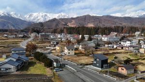 an aerial view of a small town with snow covered mountains at Hakuba Icicle House in Hakuba