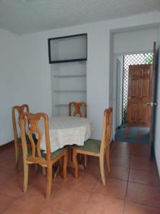 een eetkamer met een tafel en stoelen en een deur bij Casa #4 Studios in San Pedro