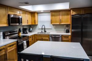Una cocina con gabinetes de madera y electrodomésticos de acero inoxidable. en BEACHVIEW 110 condo, en South Padre Island 23 fotos más