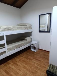 Un dormitorio con una litera y un espejo. en Cabaña La Sonrisa, en Maldonado