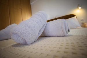 a pair of towels on top of a bed at Romanos Beach Villas in Romanu