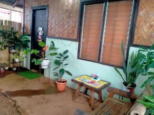 a room with a table and some plants in it at Charming Urban Hideout in Puerto Princesa City