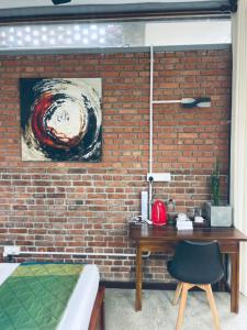 a bedroom with a brick wall and a wooden desk at Ko Lake Villa in Ahangama