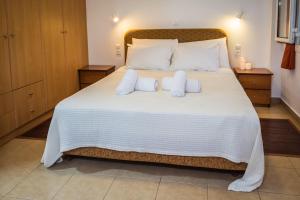 a bedroom with a large white bed with two pillows at Romanos Beach Villas in Romanu