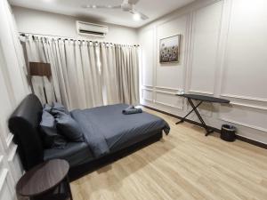 a bedroom with a bed and a table in a room at Ayu Blue Lagoon PD by GPH in Gua Sai