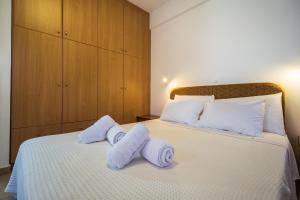 a bedroom with a bed with towels on it at Romanos Beach Villas in Romanu