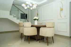 a dining room table with chairs and a chandelier at Penthouse Palmares SkyView in La Romana