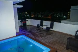 a swimming pool on the roof of a building at night at Penthouse Palmares SkyView in La Romana