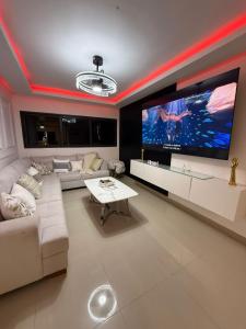 a living room with a large flat screen tv at Penthouse Palmares SkyView in La Romana