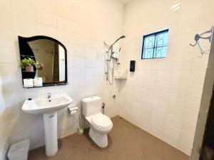 a bathroom with a toilet and a sink and a mirror at Deco Home The Oasis Mesilau at Kundasang in Kundasang +29 photos