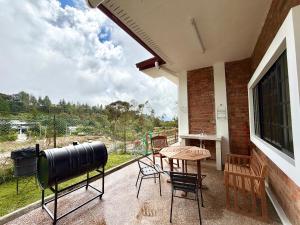 a patio with a table and chairs and a large window at Deco Home The Oasis Mesilau at Kundasang in Kundasang