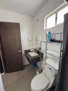 a bathroom with a toilet and a sink at Cuarto independiente frente al museo del desierto in Saltillo
