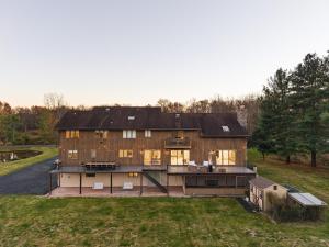 una gran casa de madera en una colina con patio en Family Staycation Retreat 7BDR Sauna Games, 
