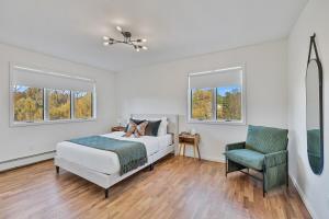 Un dormitorio blanco con una cama y una silla. en Family Staycation Retreat 7BDR Sauna Games, 