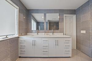 Un baño con un lavabo blanco y un espejo. en Family Staycation Retreat 7BDR Sauna Games,  36 fotos más