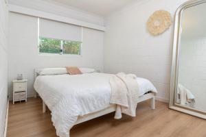 En eller flere senge i et værelse på Blueys Beach Villa Manyana 11