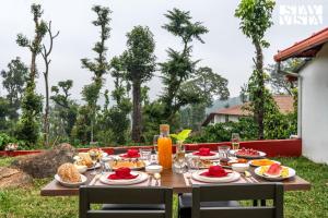 - une table en bois avec de la nourriture et des boissons dans l'établissement StayVista at Hermitage 4BR - Boutique Stay - Relax in Nature, à Irpu