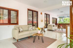 un salon avec un canapé et une table dans l'établissement StayVista at Hermitage 4BR - Boutique Stay - Relax in Nature, à Irpu