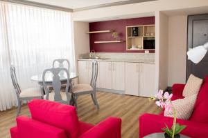 a living room with red chairs and a table at Hotel Santander Plaza in Guatemala +18 photos