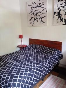 Centro de rio في ريو سيبالوس: غرفة نوم بسرير لحاف اسود وبيض