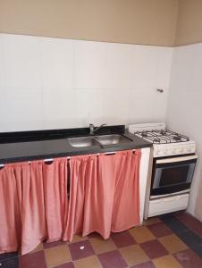 a kitchen with a sink and a stove at Centro de rio in Río Ceballos