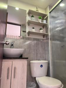 un baño con inodoro y lavabo en Poblado ApartaSuite familiar cerca club campestre, en Medellín