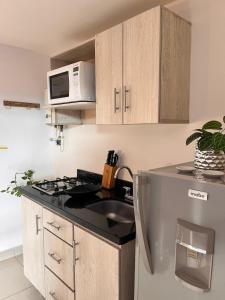 una cocina con fregadero y microondas en Poblado ApartaSuite familiar cerca club campestre, en Medellín 26 fotos más