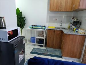 a small kitchen with a sink and a refrigerator at Naivera Membley star heights in Ruiru