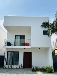a white house with a brown door at Maison Aria in Madina