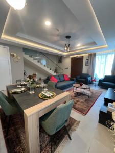 a dining room and living room with a table and chairs at Maison Aria in Madina