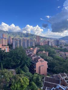 Una vista de una ciudad con edificios y árboles. en Poblado ApartaSuite familiar cerca club campestre, en Medellín