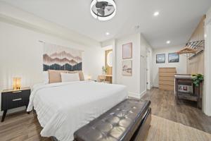 a white bedroom with a large bed and a fireplace at Whistler Lakeside Hideaway in Whistler