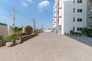 拉合尔Prestigious Apartments with Signature Luxury Furnish - Zameen Opal Lahore的白色建筑旁的空人行道