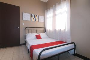 a small bedroom with a bed and a window at RedDoorz at Aurea Apartelle in Iloilo City