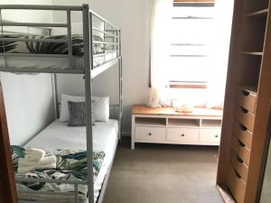 een kamer met 2 stapelbedden en een bureau bij Relaxing Vintage Cottage in Corrimal