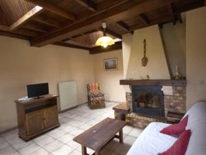 Gîte familial avec jeux extérieurs près de St-Galmier - FR-1-496-281 في Saint-Médard-en-Forez: غرفة معيشة مع أريكة ومدفأة +7 صور